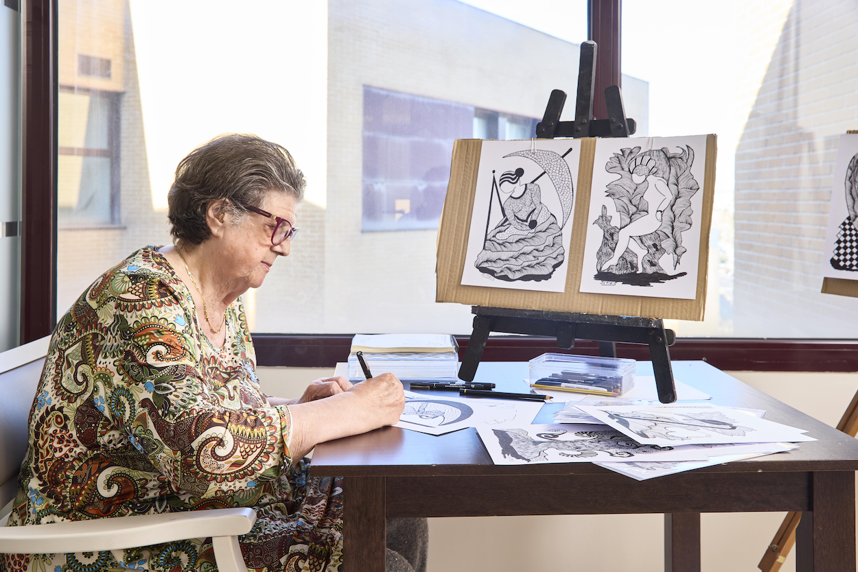 Una persona mayor participa en una actividad de pintura en un centro Bouco 2