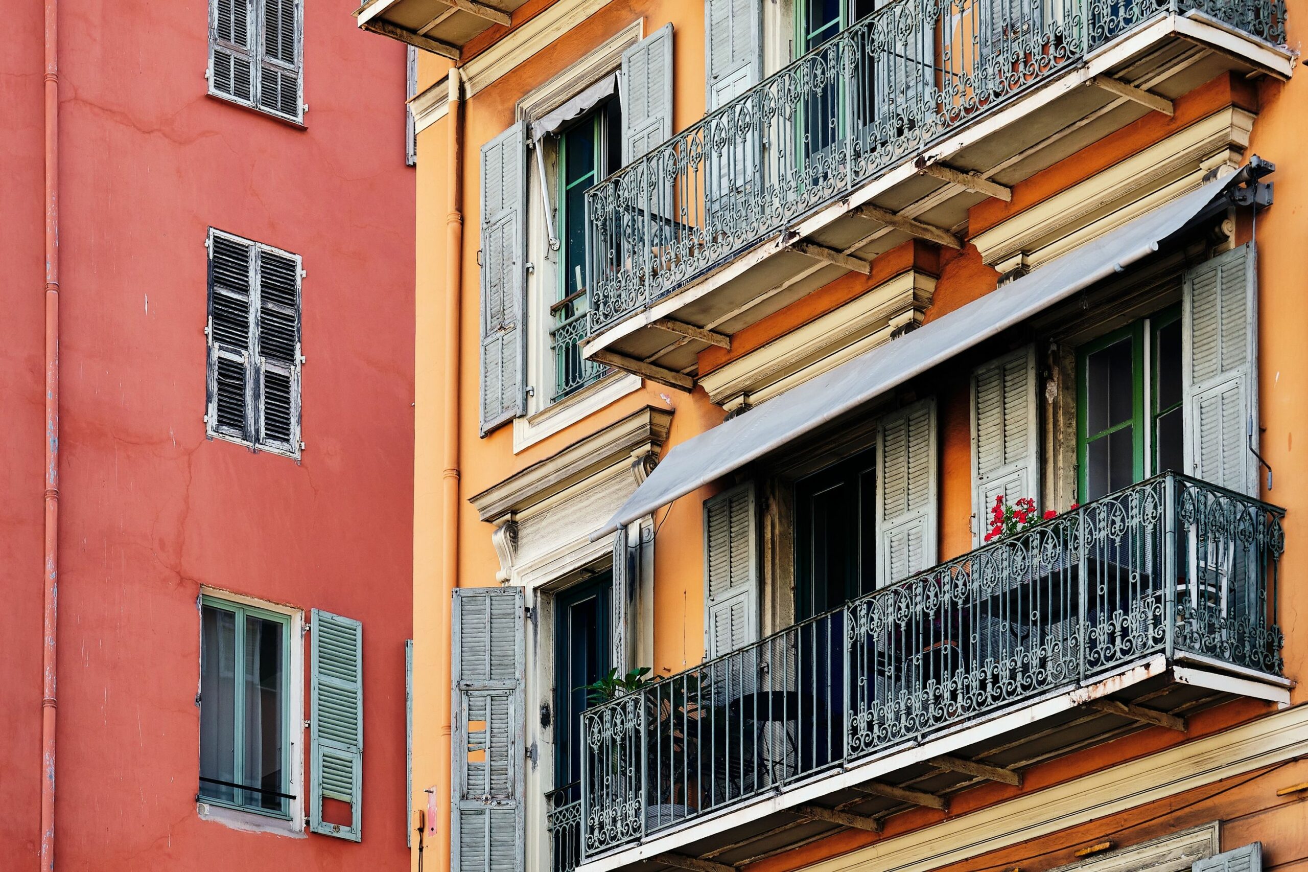colorida arquitectura de las ventanas balcones de un edificio rojo en niza francia scaled